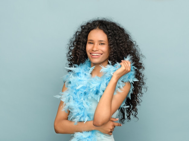 Happy young black woman in a fashion portrait on blue