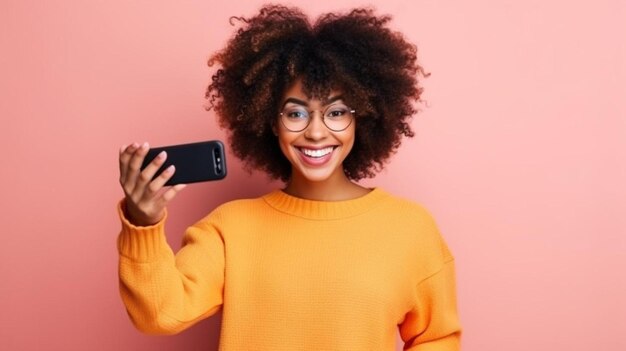 Happy young black woman in stylish sweater leaning on wall and taking selfie via smartphone