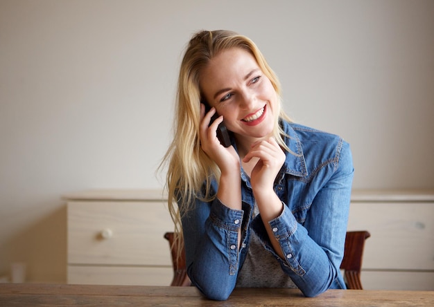 happy young blond woman talking on cellphone