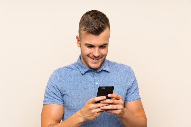 Happy Young blonde man using mobile phone