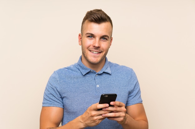 Happy Young blonde man using mobile phone