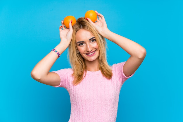 Happy  Young blonde woman holding fruits