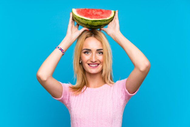 Счастливая молодая блондинка женщина, держащая фрукты