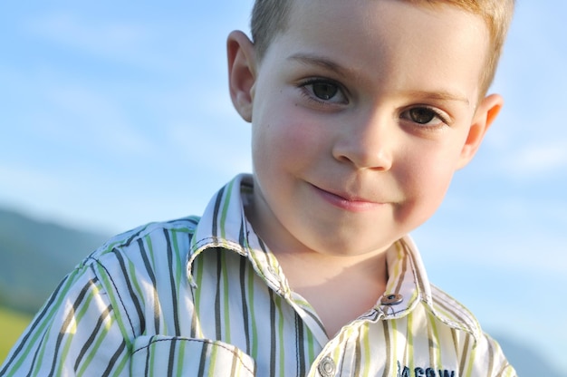 幸せな若い男の子の子供の屋外のポートレート