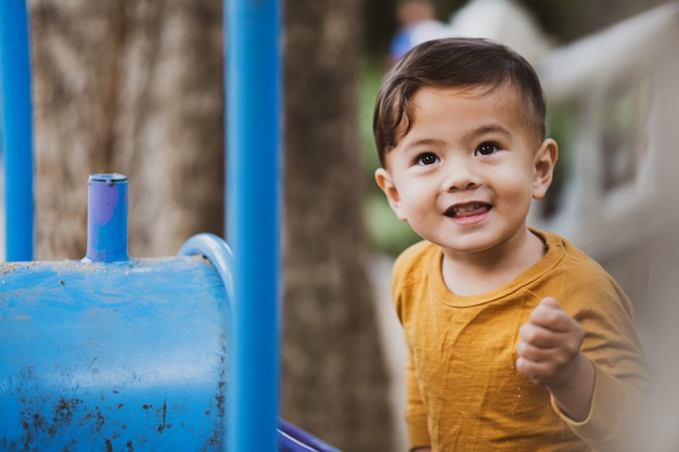 Happy young boy playing outdoors in the park