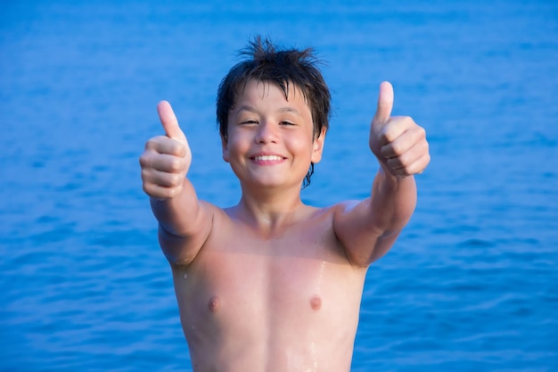 Happy young boy on the sea beach OK