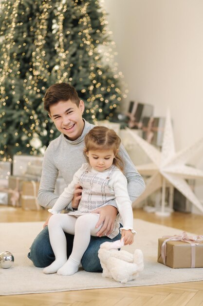 Happy young boy with his niece play in front of fir tree christmas mood