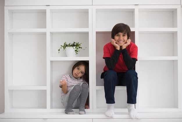 happy young boys are having fun while posing on a shelf in a new modern home