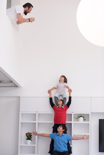 happy young boys having fun and posing line up piggyback in new modern home