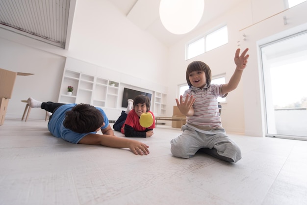 happy young boys having fun with an apple on the floor in a new modern home