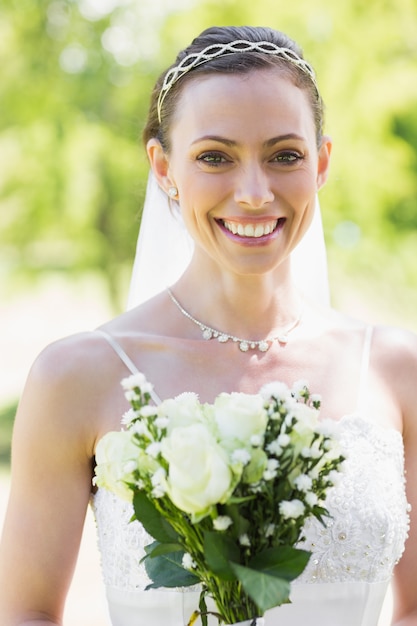 Foto giovane sposa felice con i fiori in giardino