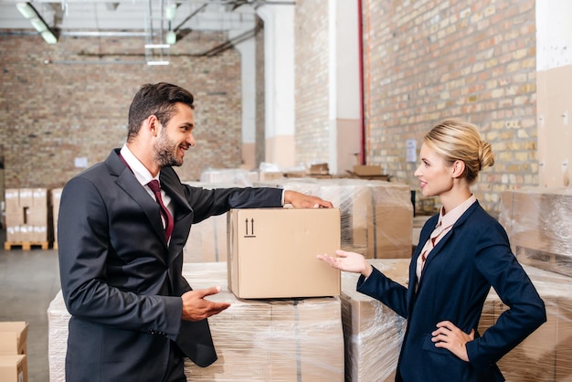 Happy young business colleagues talking at warehouse