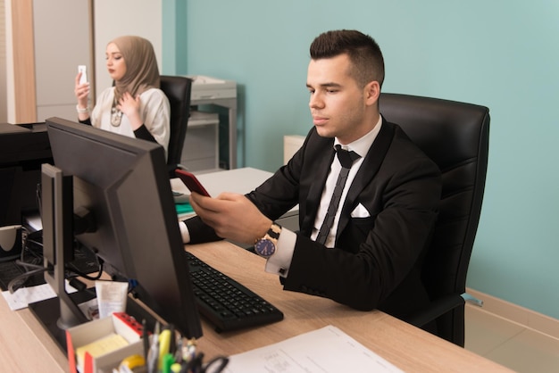 Happy Young Business Man And Muslim Woman Work In Modern Office On Computer