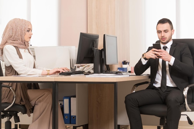 Happy Young Business Man And Muslim Woman Work In Modern Office On Computer