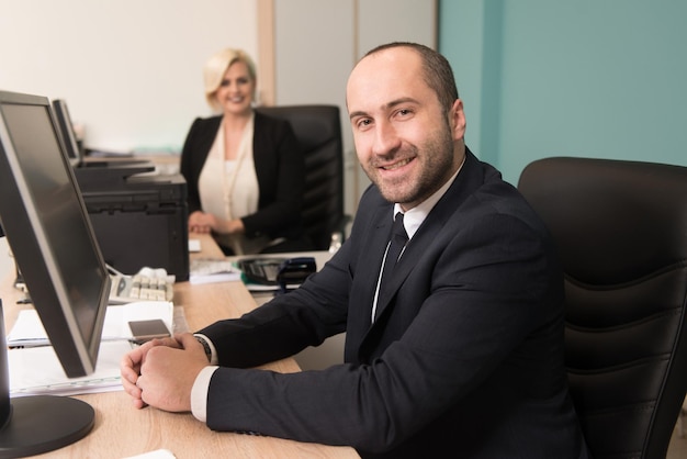 Foto felice giovane uomo d'affari e donna lavorare in ufficio moderno sul computer