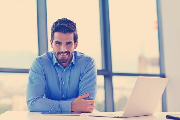 Happy young business man work in modern office on computer