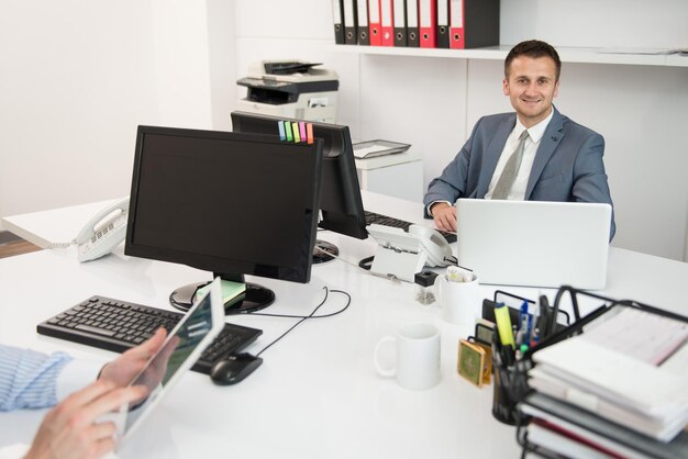 Foto giovani uomini d'affari felici lavorano in un ufficio moderno sul computer