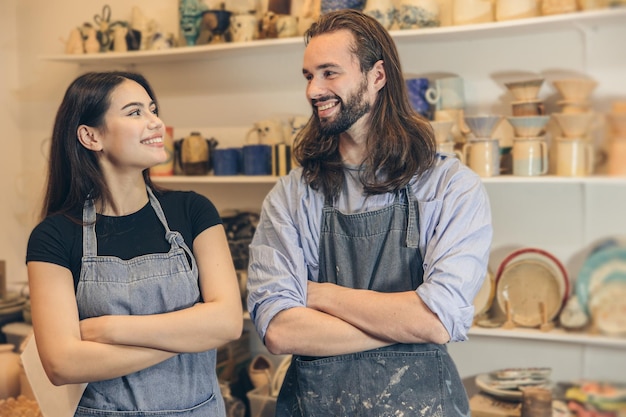 Happy young business owner couple friends lover with pottery ceramic shop store