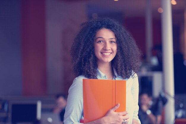 Happy young business woman with curly hairstyle in the modern office