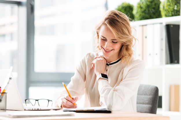 happy young business woman writing notes.
