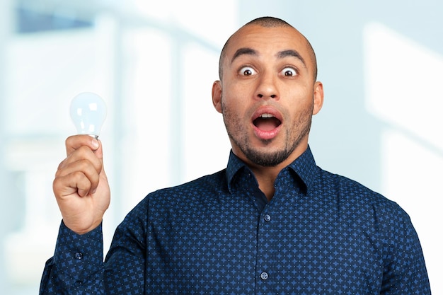 Happy Young Businessman Holding Light Bulb