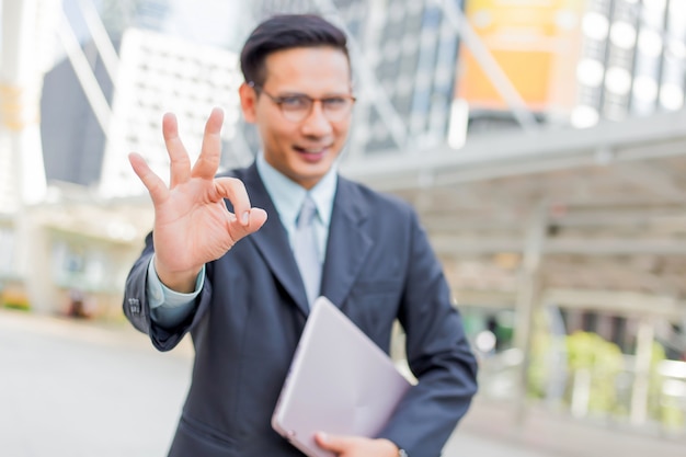 Happy young businessman make okay gesture. okay symbol.