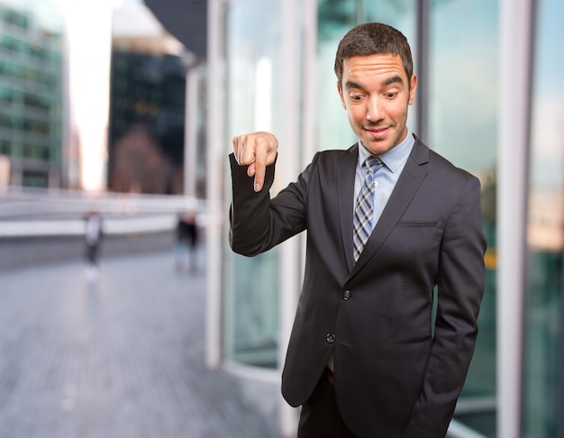 Happy young businessman pointing