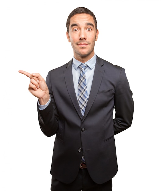 Happy young businessman pointing