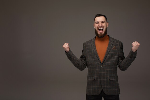 Happy Young Businessman Presenting Isolated Over Grey Background. Copyspace.