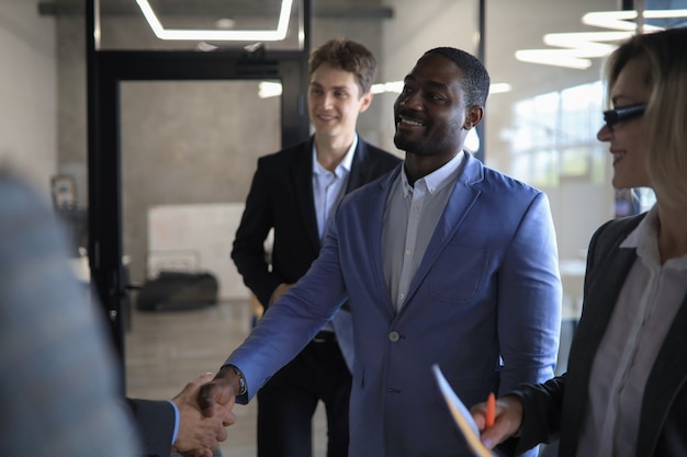 Happy young businessman shaking hands with his business partner.