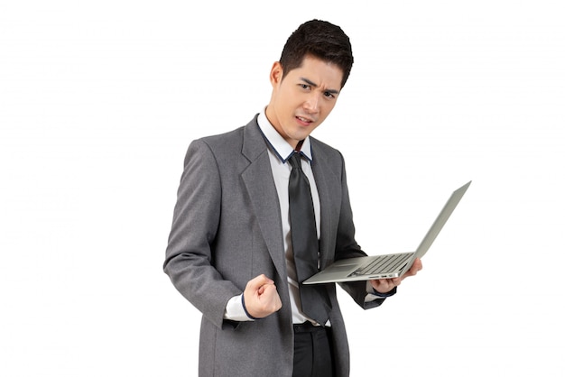 Happy young businessman standing arm up and hold laptop in suit, isolated concept