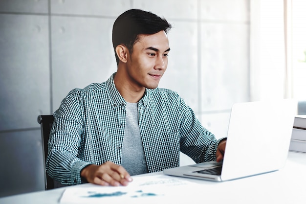 Photo happy young businessman working on computer laptop in office