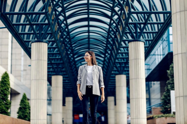 A happy young businesswoman is walking at the business center