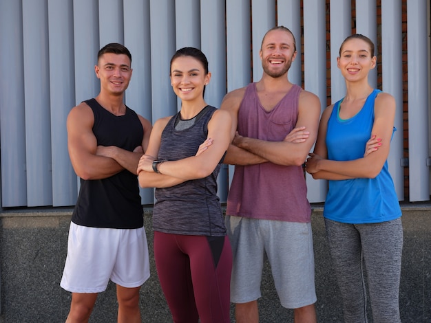 Happy young caucasian athletes standing with crossed hands