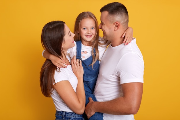 Happy young Caucasian family in photo studio.