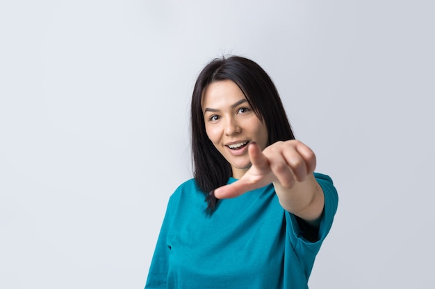 指を離れて指している青いTシャツで幸せな若い白人女性