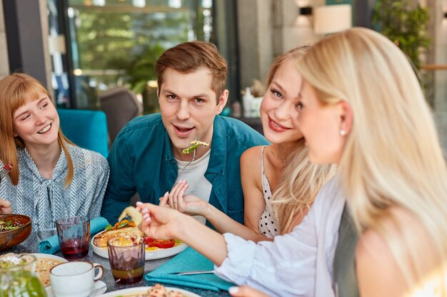 写真 カフェに集まる幸せな若い白人の友人