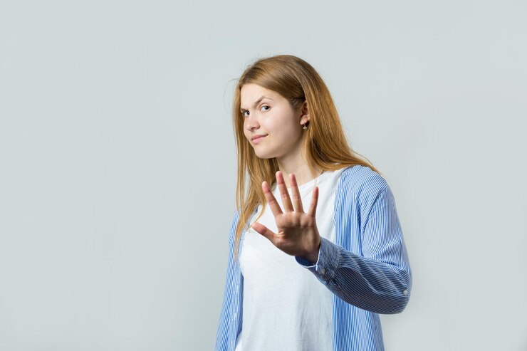 Happy young caucasian redhead female in summer shirt lifts a clenched fist up for joy Success and happiness of the work Successful person victory