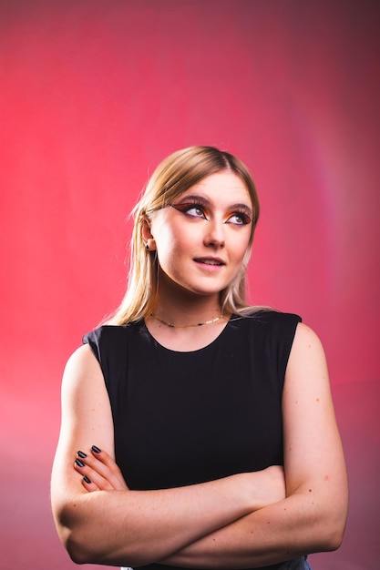 Happy young caucasian woman in a photography studio with a red background.