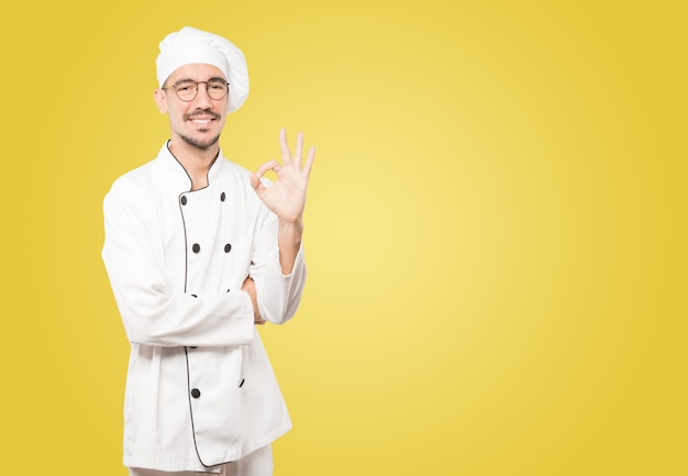 Happy young chef doing an all right gesture