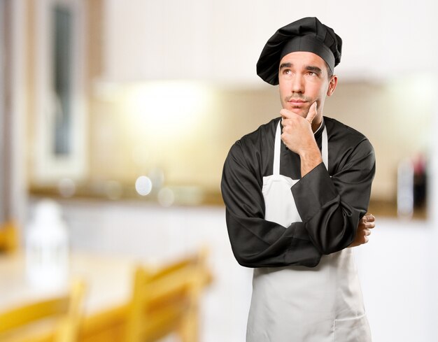 Photo happy young chef doubting