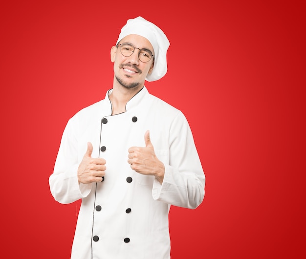 Happy young chef gesturing that everything is fine