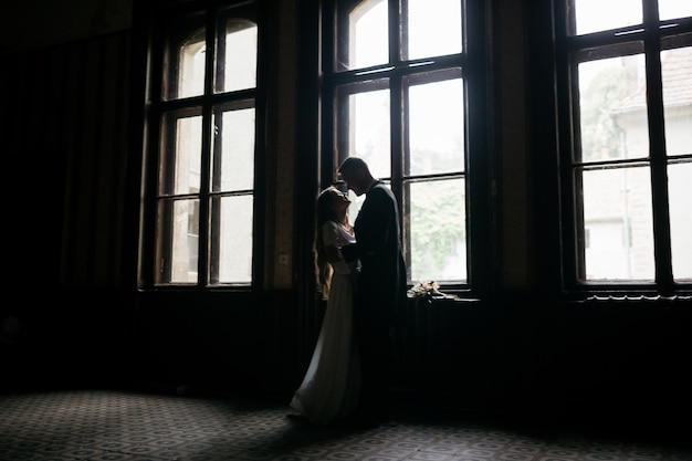 Happy young couple Brides in hats Young girl in a white wedding dress and hat with a bouquet of flowers Brides in the castle Bride and groom