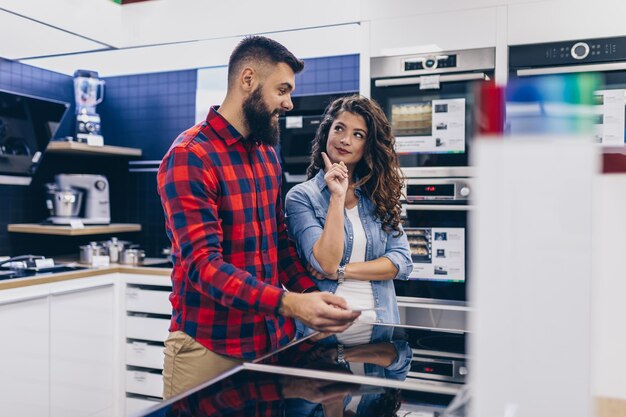 Happy Young Couple Buying Household Appliances In Store.