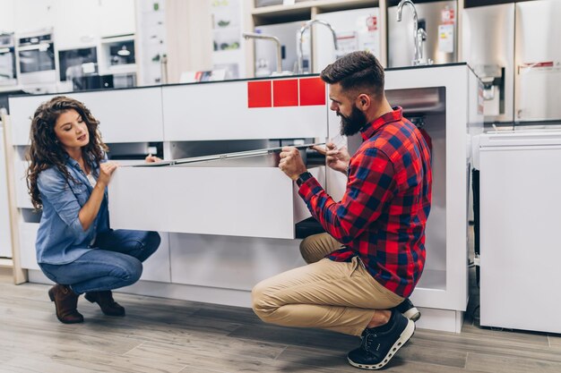 Happy Young Couple Buying Household Appliances In Store.