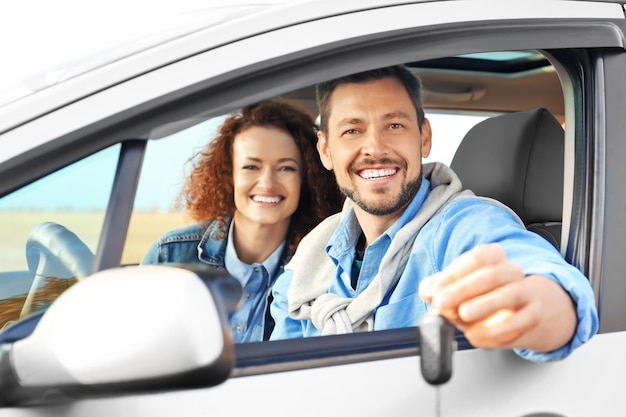 Happy young couple in car