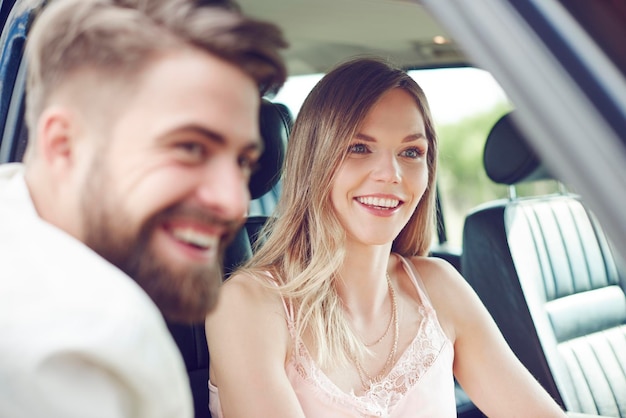 Happy young couple in car