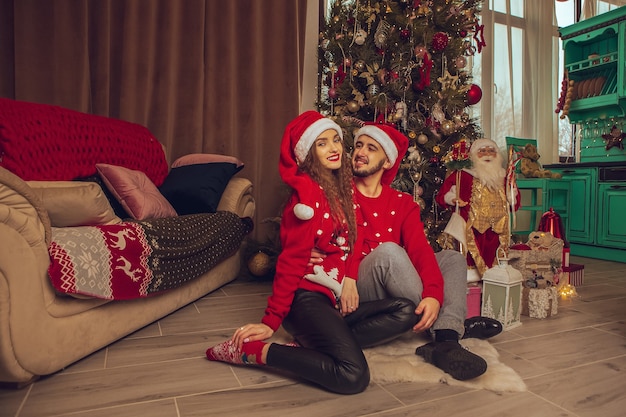 幸せな若いカップルは家で一緒にクリスマスと新年を祝います