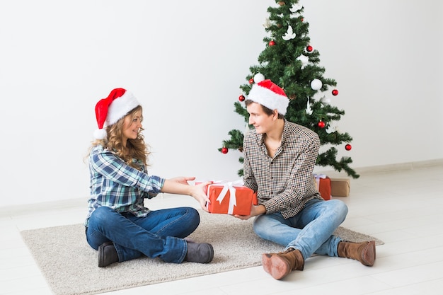 家でクリスマスを祝う幸せな若いカップル。