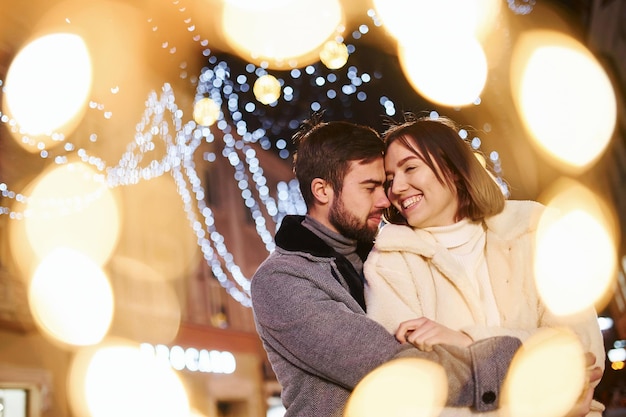 Happy young couple celebrating New year outdoors on the street